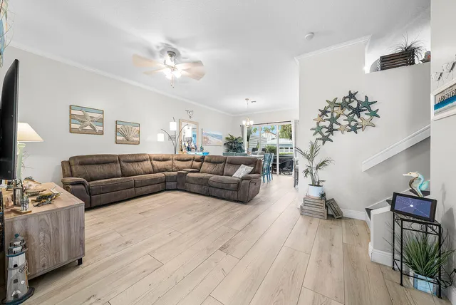 a living room with furniture and a ceiling fan