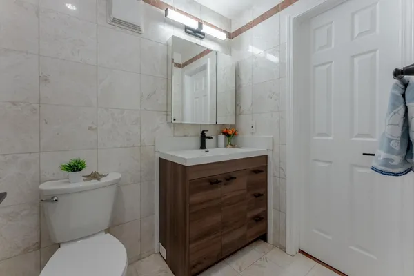 a bathroom with a granite countertop toilet sink and mirror