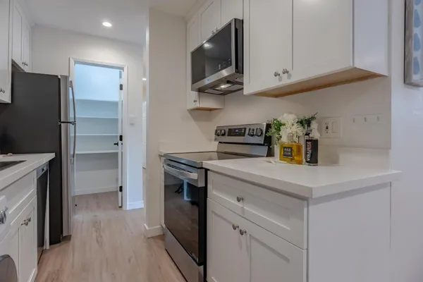 a kitchen with stainless steel appliances white cabinets and a refrigerator