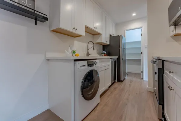 a utility room with cabinets washer and dryer