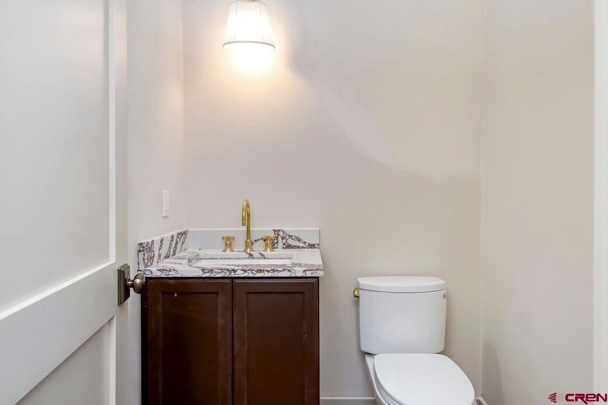 180 Elk Valley Road, Unit 112 Crested Butte, CO 81224 - Photo 8 of 27 a bathroom with a granite countertop toilet and a sink