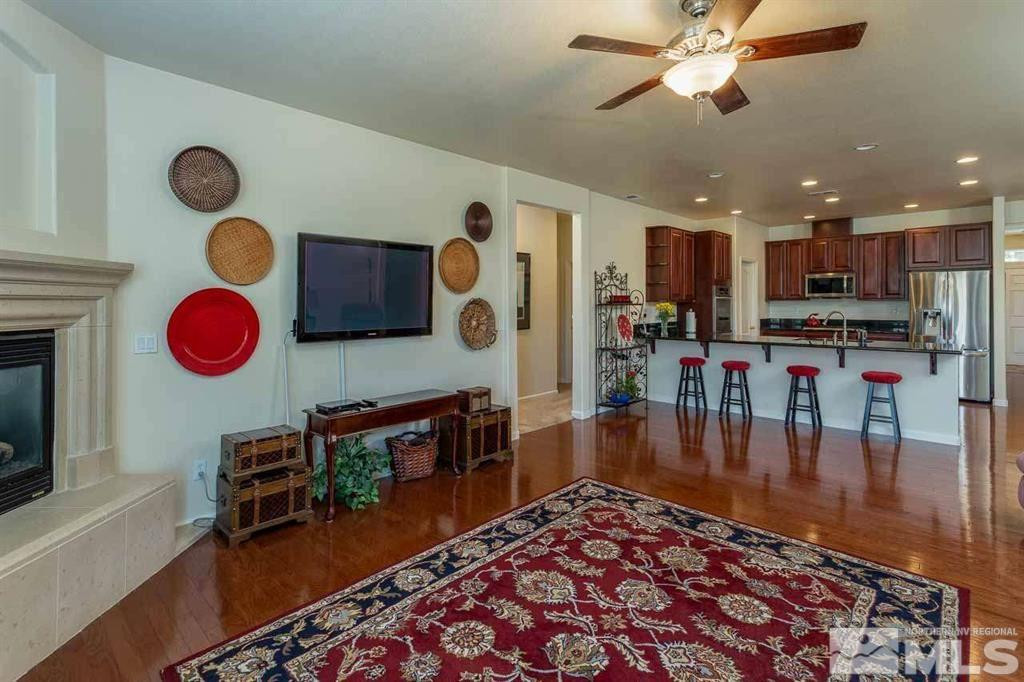 10845 Dancing Aspen Drive Reno, NV 89521 - Photo 5 of 9 a very nice looking open kitchen with stainless steel appliances granite countertop a stove top oven a dining table and chairs with wooden floor