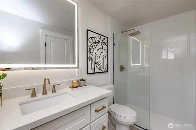 a bathroom with a sink a toilet and shower