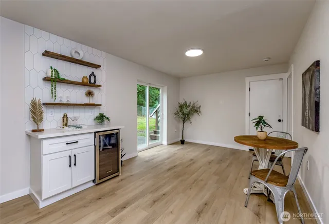 a kitchen with granite countertop a table chairs stove and wooden floor