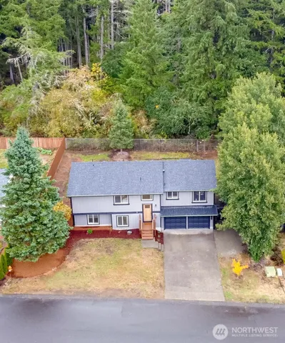 an aerial view of a house with swimming pool and large trees