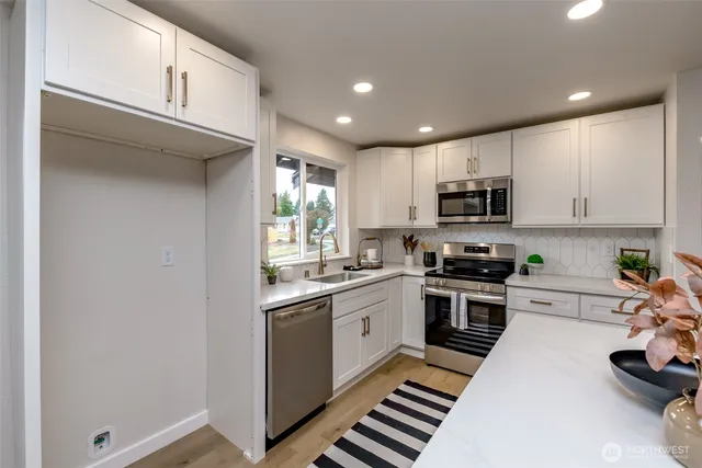 a kitchen with stainless steel appliances granite countertop a sink and cabinets