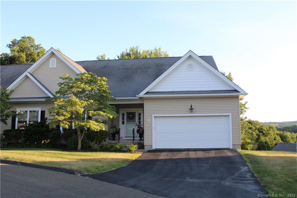 a front view of a house with a yard garage and outdoor seating