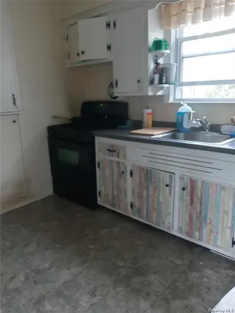 a kitchen with granite countertop white cabinets and sink