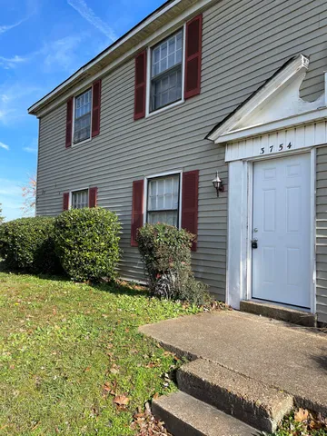 a kitchen with white cabinets and refrigerator