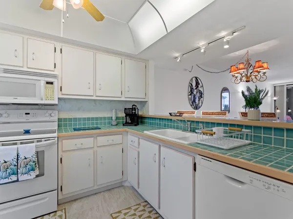 a kitchen with granite countertop white cabinets and white appliances