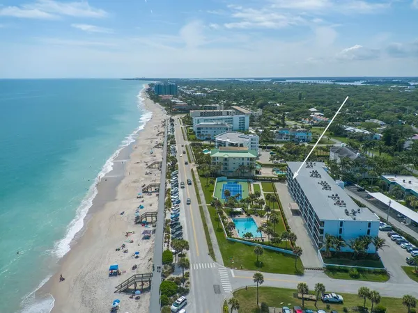 an aerial view of a residential houses with outdoor space and ocean view