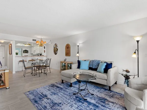 a living room with furniture and a dining table with rug