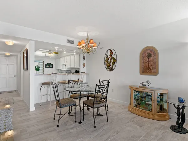 a kitchen with stainless steel appliances kitchen island granite countertop a table chairs stove a sink and a refrigerator