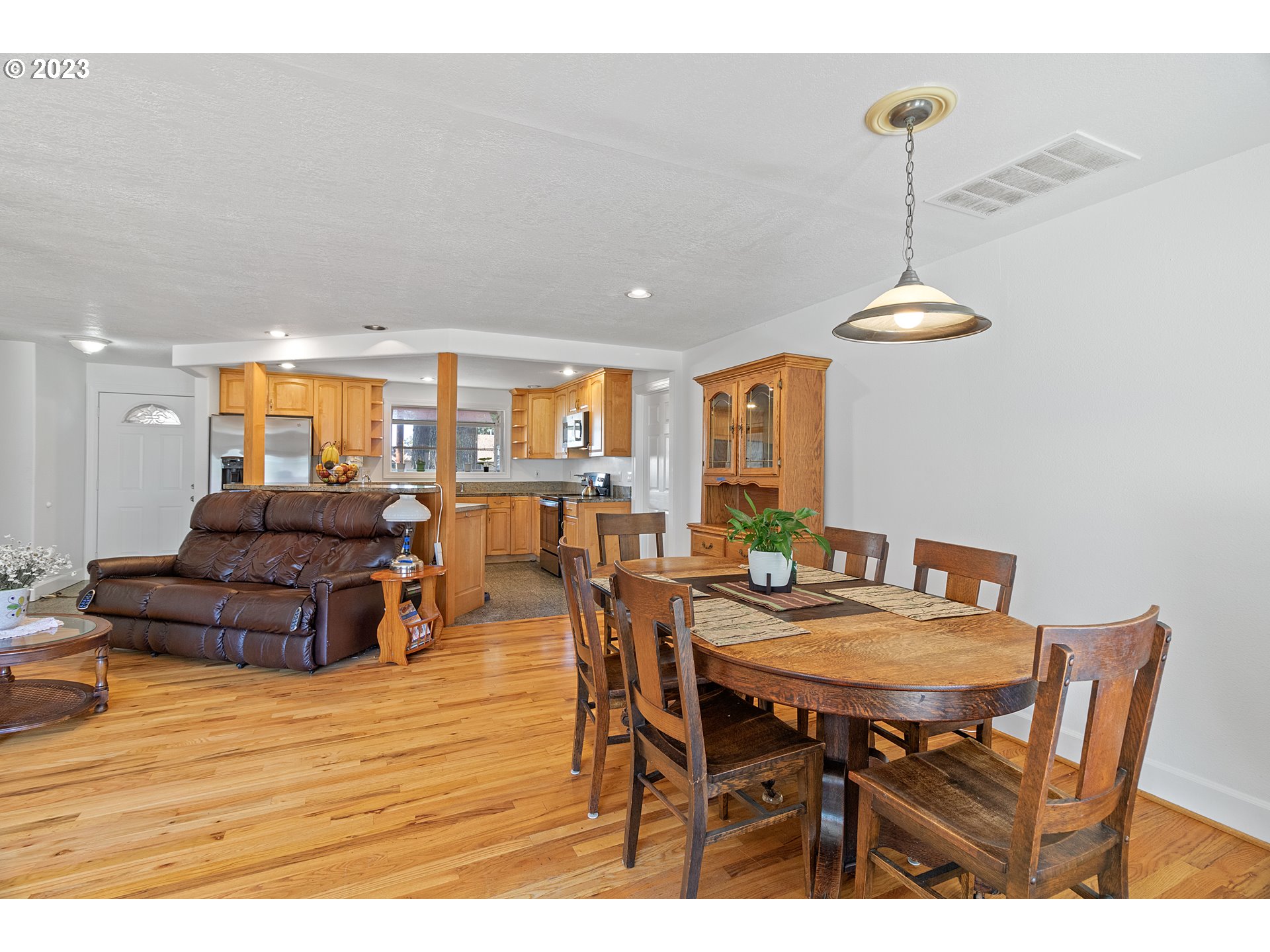 19600 Leland Road Oregon City, OR 97045 - Photo 10 of 34 a dining room with furniture a chandelier and wooden floor
