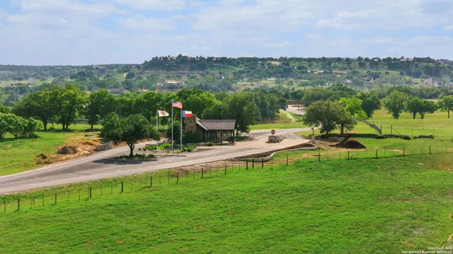 a view of a lake with a yard and large trees