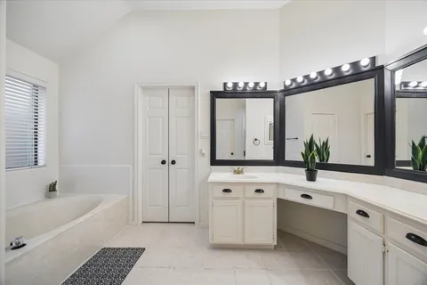 a bathroom with a bathtub a double vanity sink and mirror