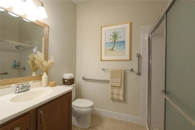 a bathroom with a toilet a sink a mirror and a shower