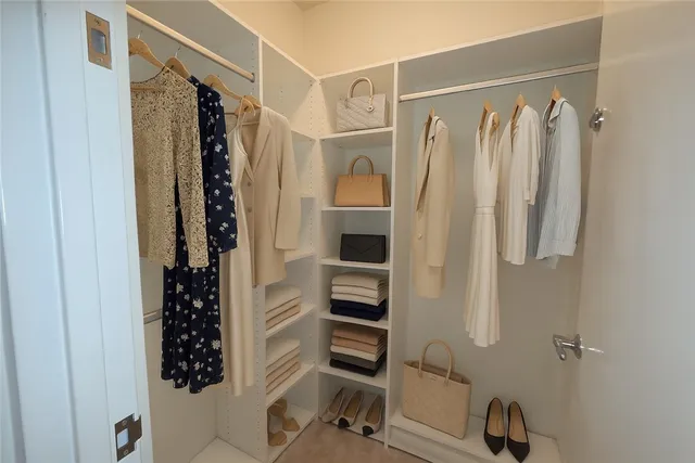 a view of walk in closet with clothes and shoes