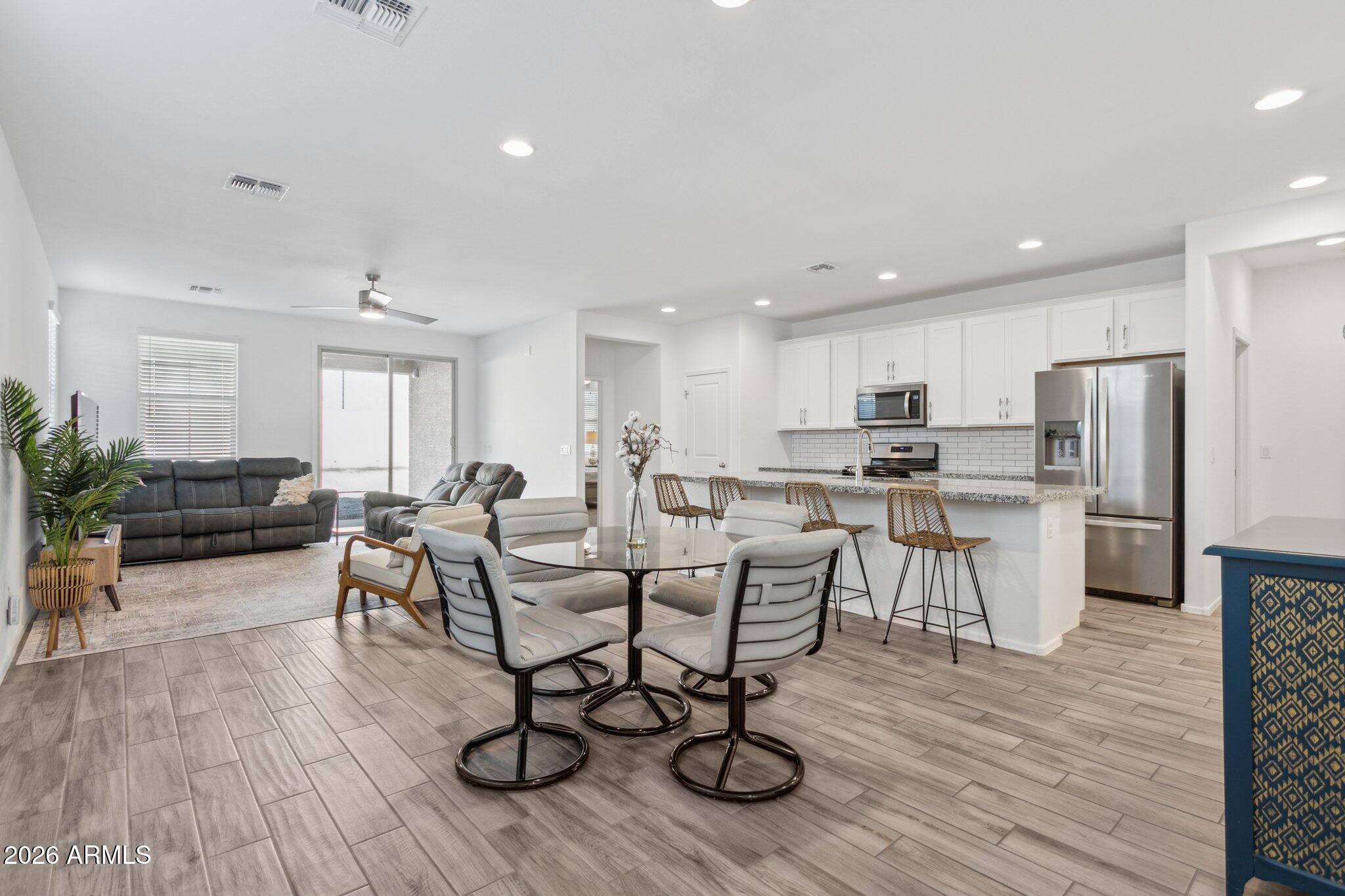 a view of kitchen with stainless steel appliances refrigerator microwave dining table and chairs