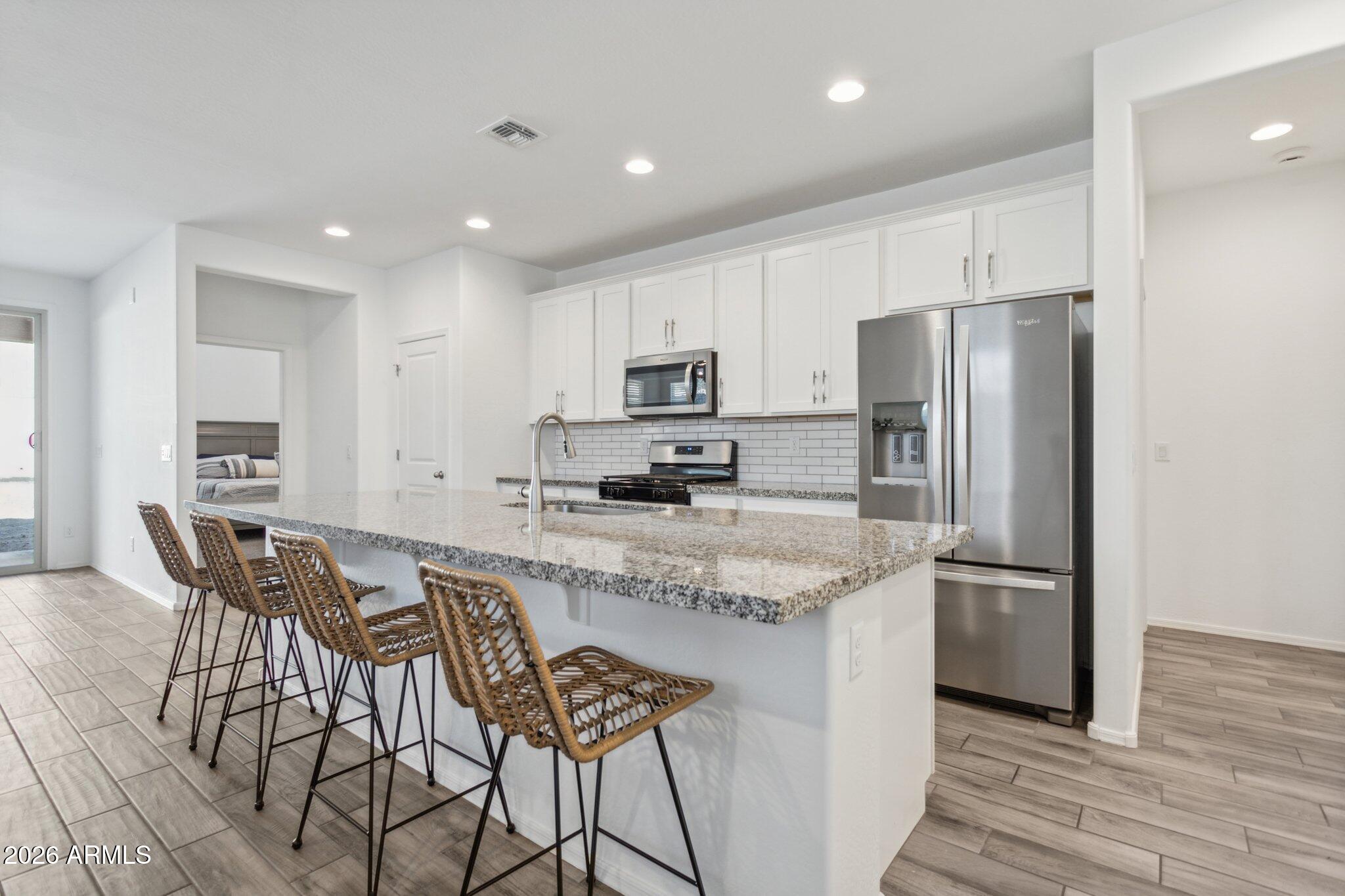 17334 West Wandering Creek Road Goodyear, AZ 85338 - Photo 10 of 67 a kitchen with stainless steel appliances granite countertop a refrigerator and a stove top oven