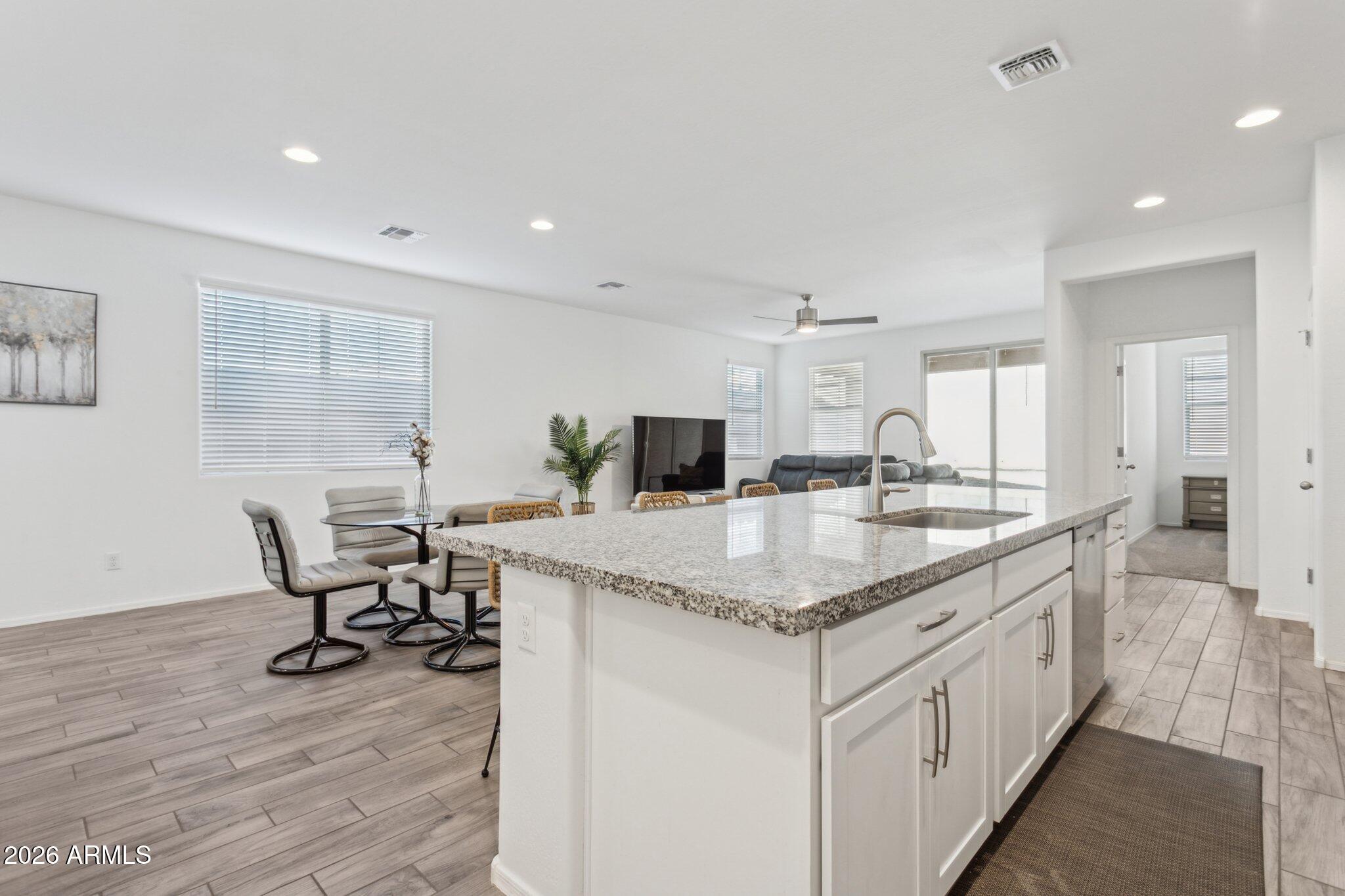 17334 West Wandering Creek Road Goodyear, AZ 85338 - Photo 11 of 67 a kitchen with stainless steel appliances kitchen island granite countertop a sink and cabinets