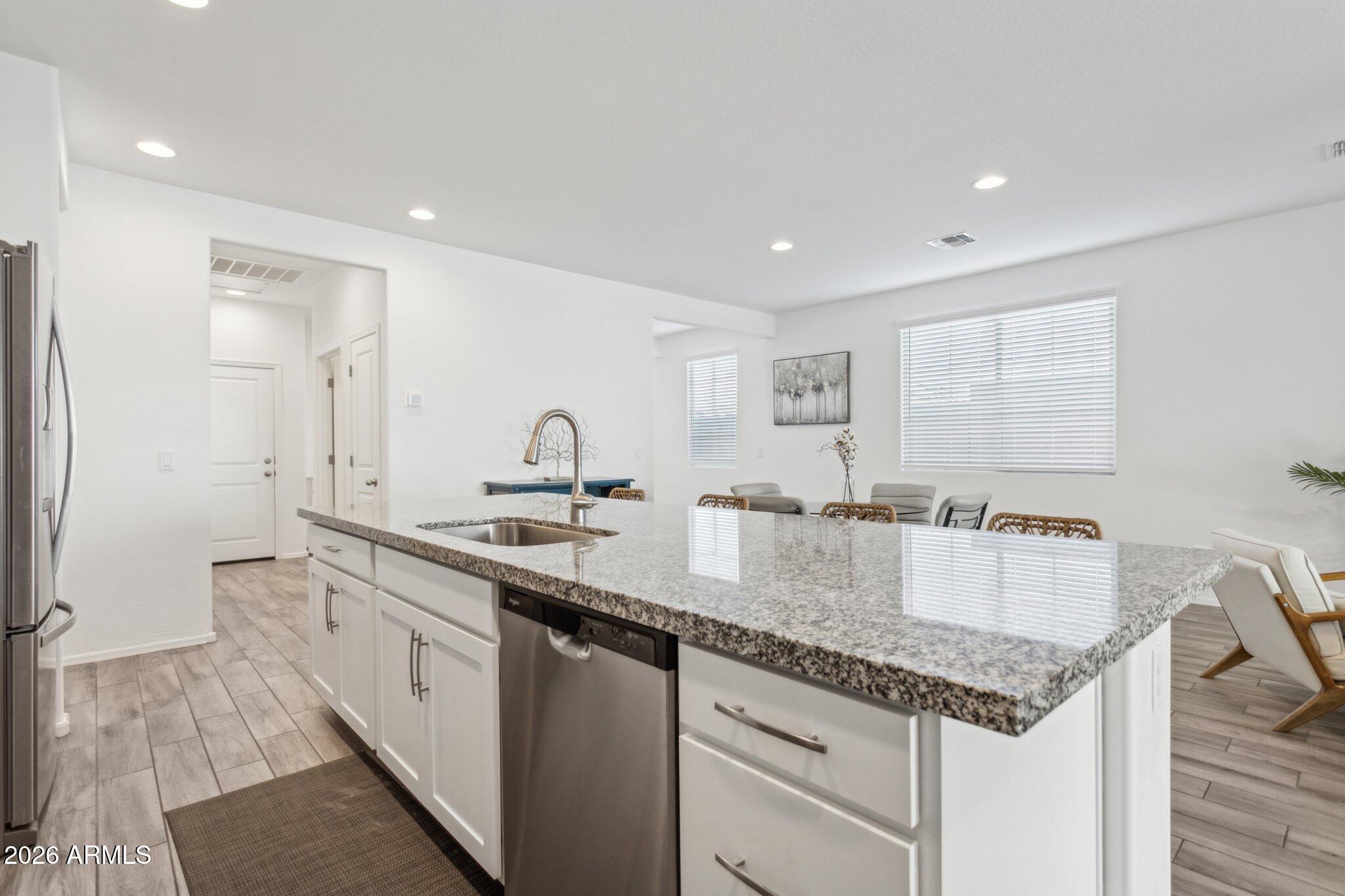 17334 West Wandering Creek Road Goodyear, AZ 85338 - Photo 13 of 67 a kitchen with center island counter top space a sink stainless steel appliances and cabinets