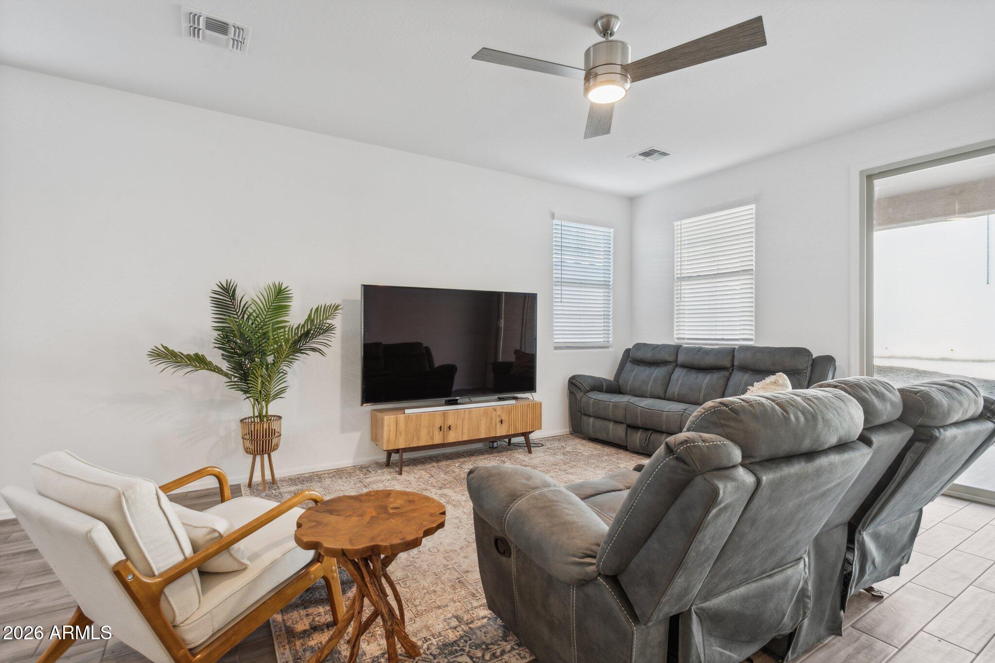 17334 West Wandering Creek Road Goodyear, AZ 85338 - Photo 14 of 67 a living room with furniture and a flat screen tv
