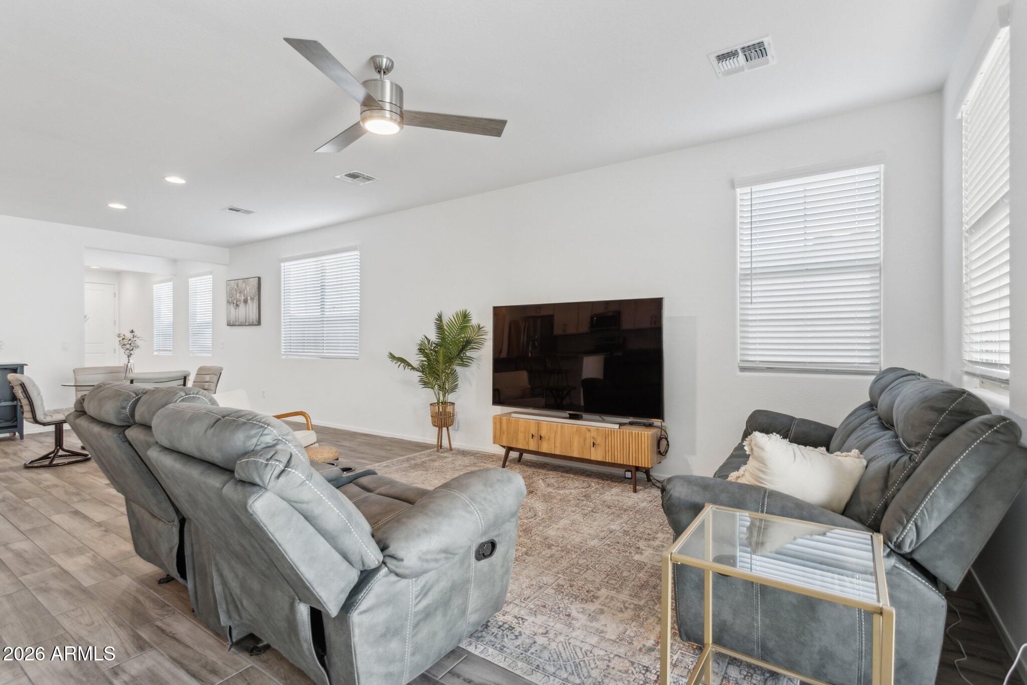 17334 West Wandering Creek Road Goodyear, AZ 85338 - Photo 15 of 67 a living room with furniture and a flat screen tv