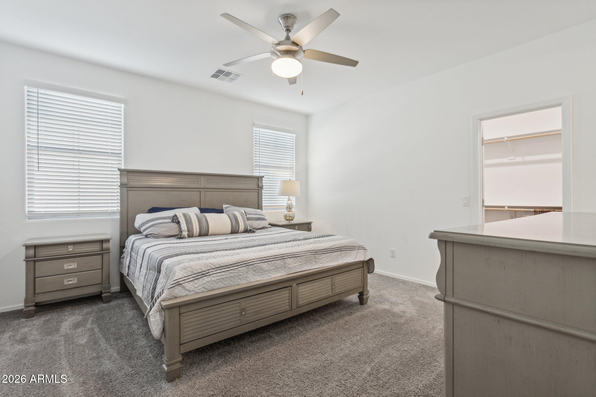17334 West Wandering Creek Road Goodyear, AZ 85338 - Photo 17 of 67 a bedroom with a bed and a window