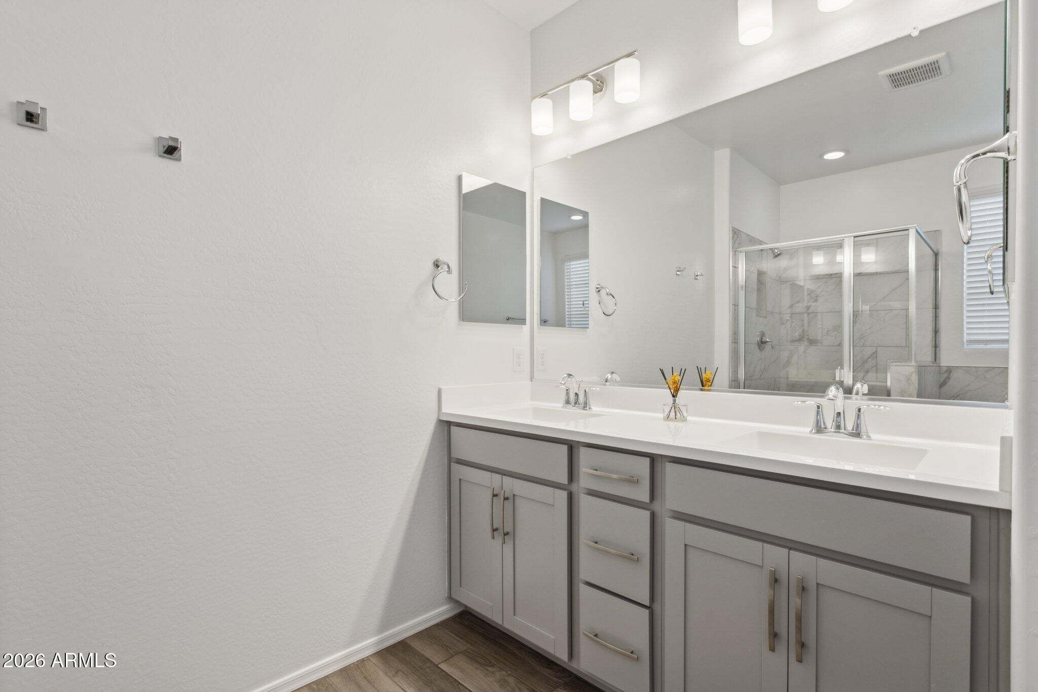 17334 West Wandering Creek Road Goodyear, AZ 85338 - Photo 19 of 67 a bathroom with a double vanity sink and mirror