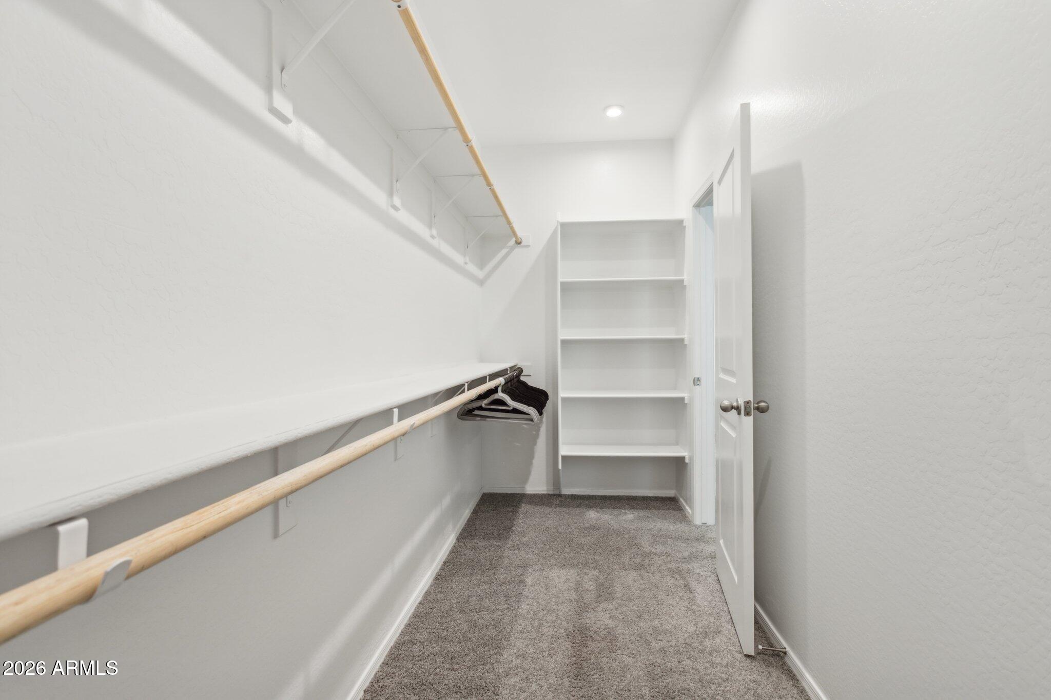 17334 West Wandering Creek Road Goodyear, AZ 85338 - Photo 21 of 67 a view of walk in closet with empty racks