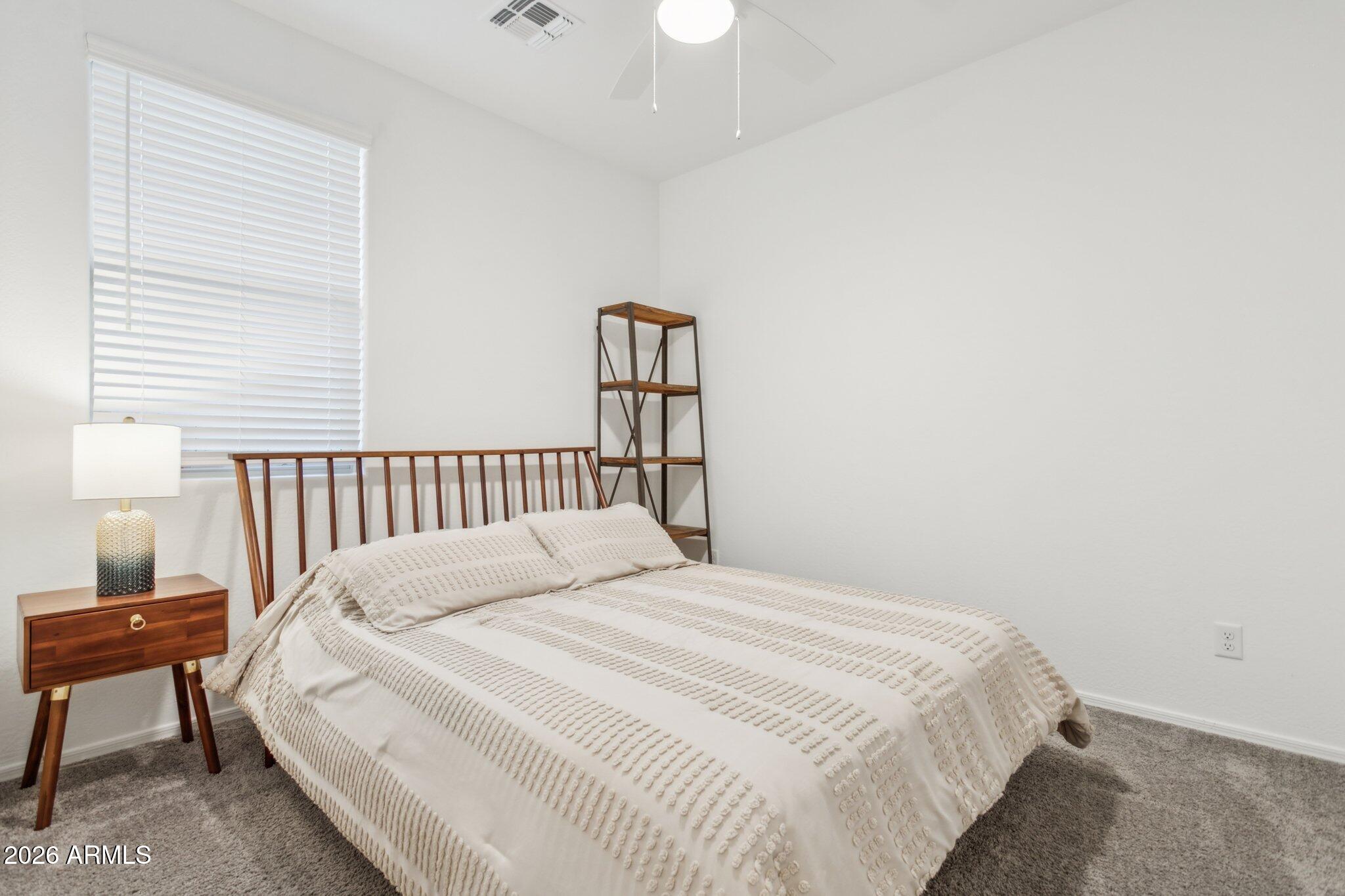 17334 West Wandering Creek Road Goodyear, AZ 85338 - Photo 25 of 67 a bedroom with a bed and a window