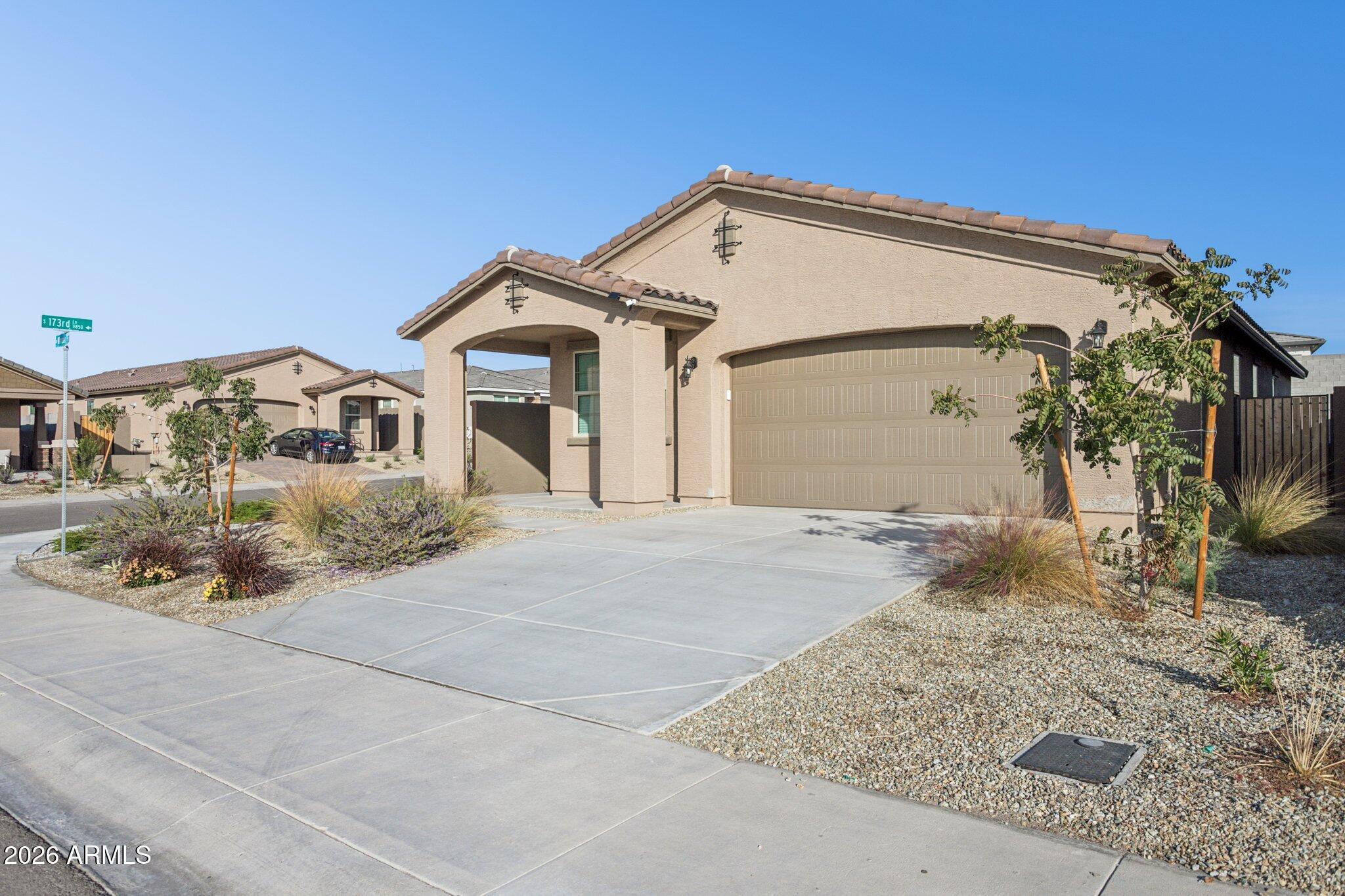 17334 West Wandering Creek Road Goodyear, AZ 85338 - Photo 3 of 67 a front view of a house with a yard and garage