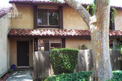 front view of a house with a yard and potted plants