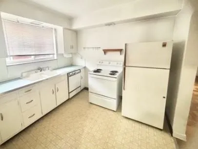 a kitchen with a refrigerator sink stove and cabinets