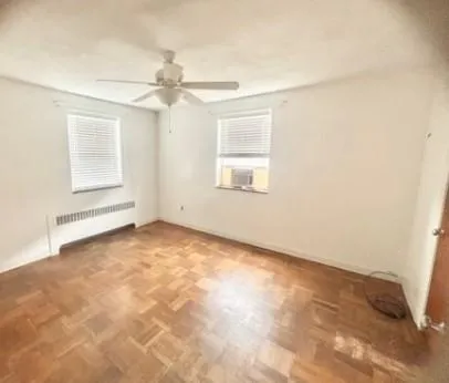 an empty room with windows and fan