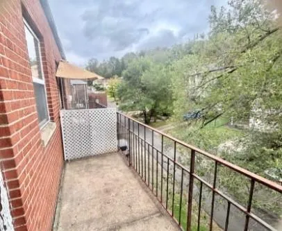 a view of a balcony with wooden floor and fence