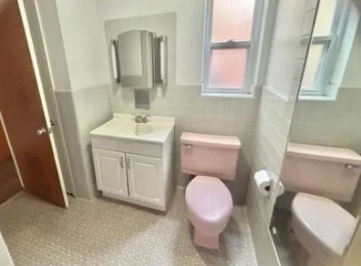 a bathroom with a sink toilet vanity and mirror