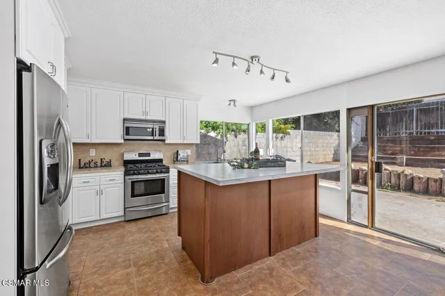 a kitchen with stainless steel appliances a stove sink and refrigerator