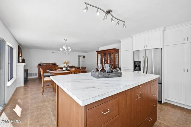 a view of kitchen island a sink and refrigerator