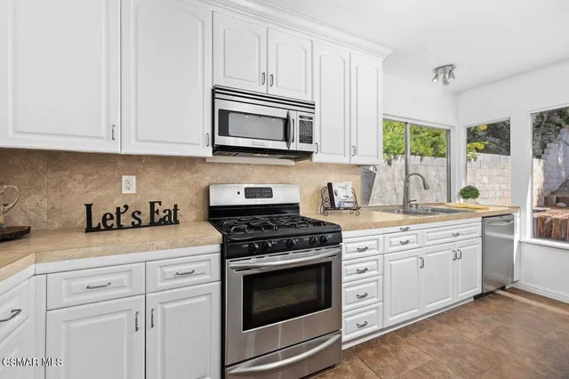 a kitchen with white cabinets and white appliances