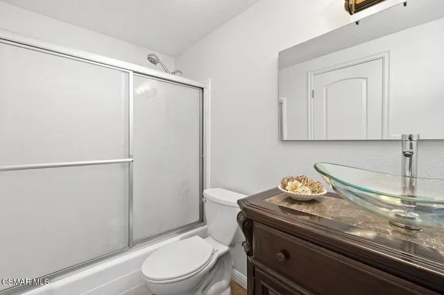 a bathroom with a sink a toilet and mirror