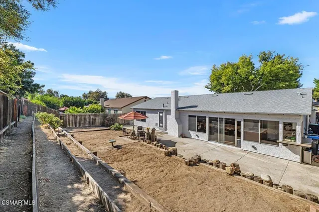 a view of a house with backyard and sitting area
