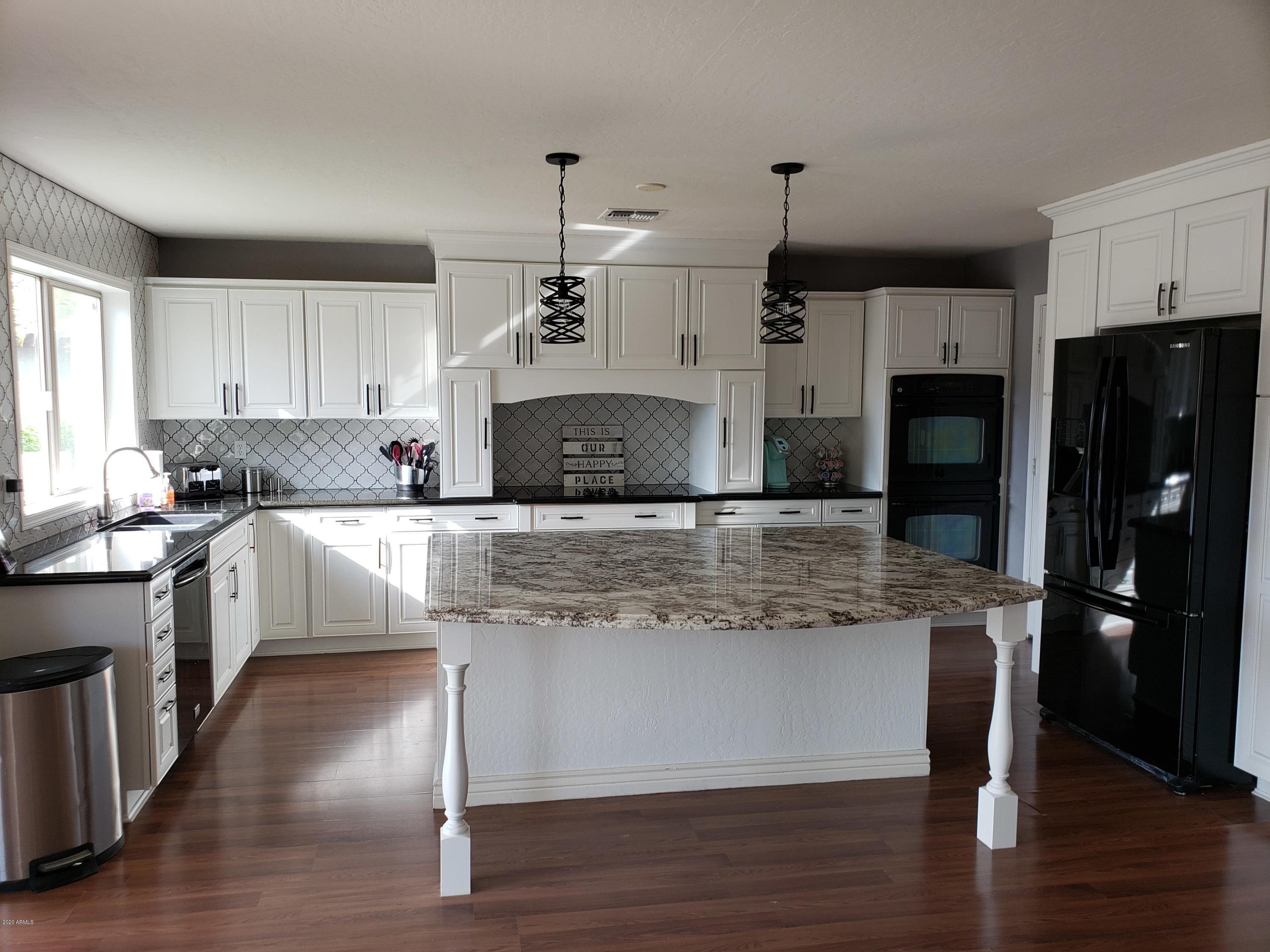 2917 West Fremont Rd. Phoenix, AZ 85041 - Photo 12 of 41 a kitchen with stainless steel appliances granite countertop a stove a refrigerator a sink and a oven with wooden floor