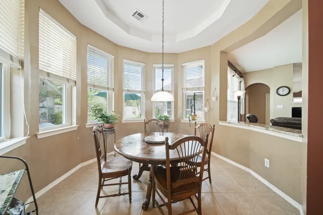 a dining room with furniture a chandelier and wooden floor