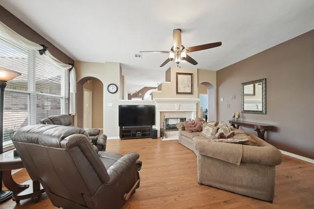 a living room with furniture a fireplace and a flat screen tv