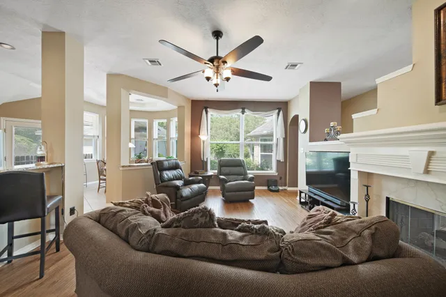 a living room with furniture a fireplace and a large window