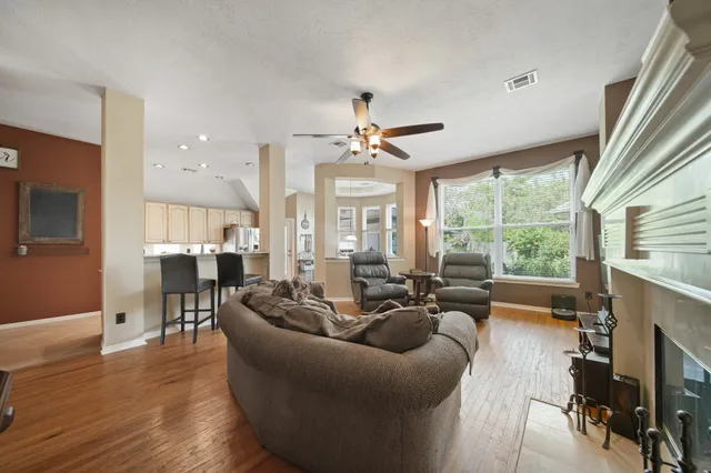 a living room with fireplace furniture and a large window