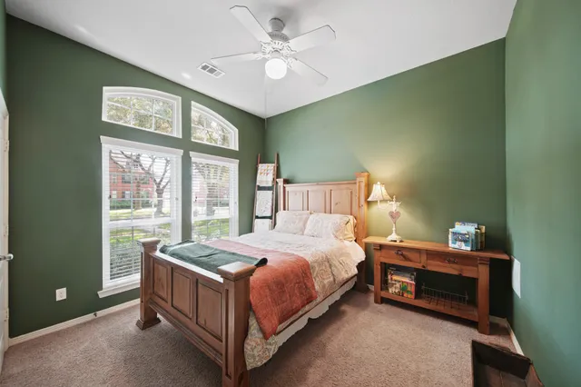 a bedroom with a bed and a large window