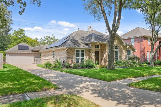 a front view of a house with a yard and potted plants